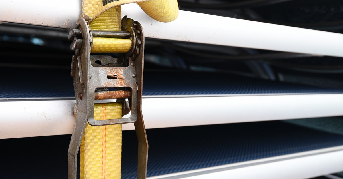 Metal patio chairs are secured tightly in place with bright yellow ratchet straps for added stability and safety.