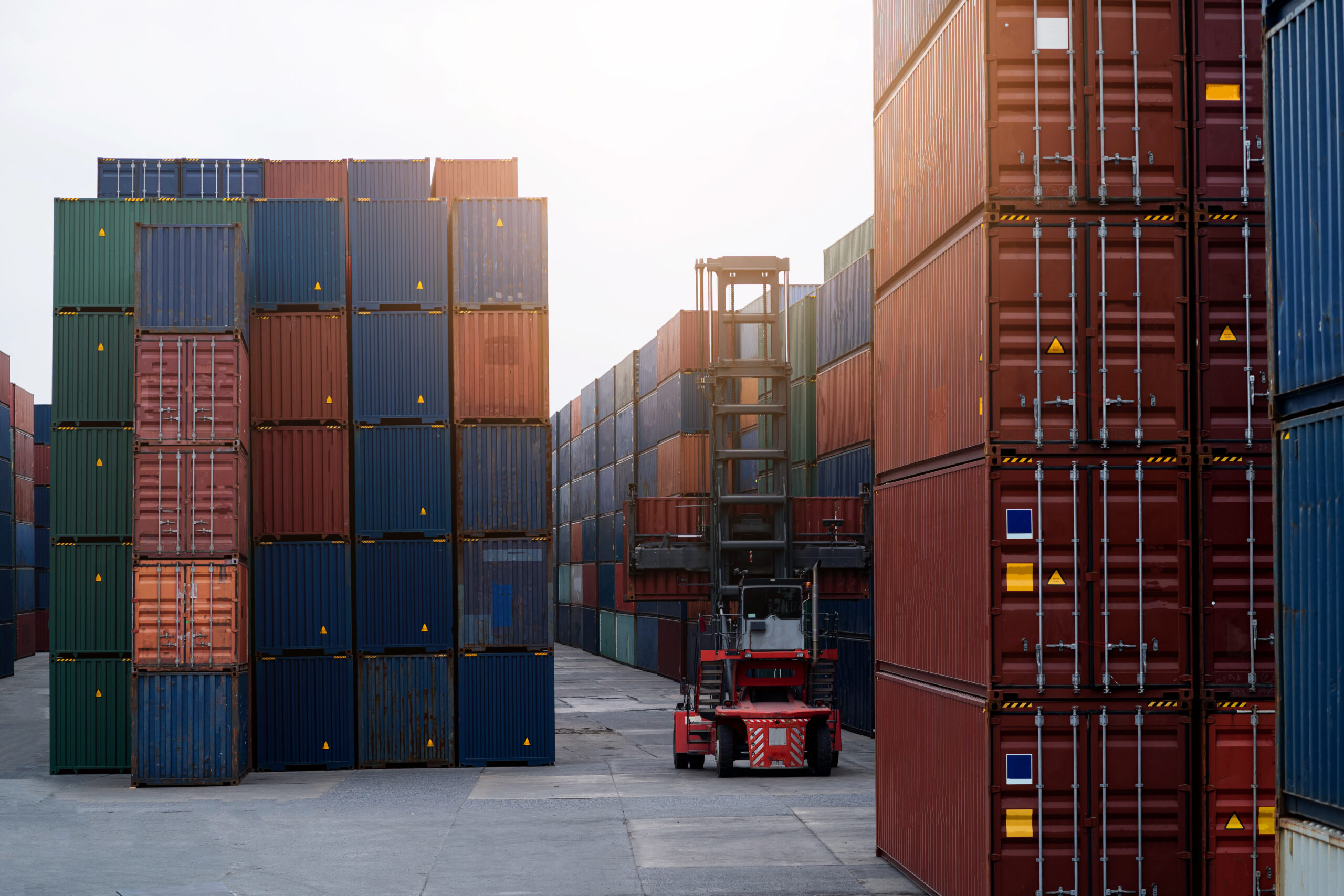 A large red container is being lifted by a forklift costs of freight damage